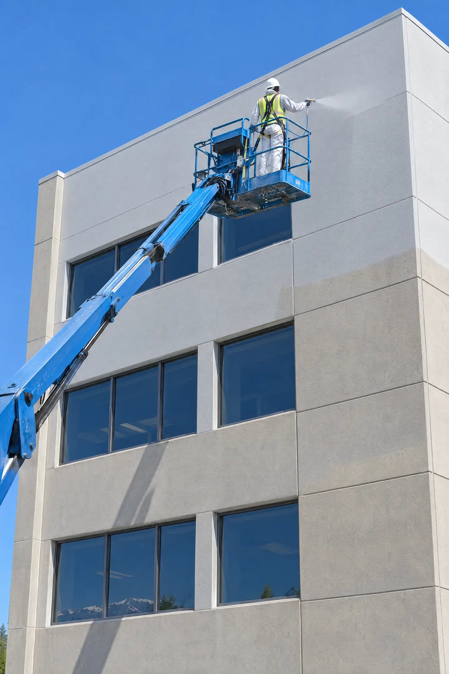 Commercial facade with a boom lift positioned for exterior painting